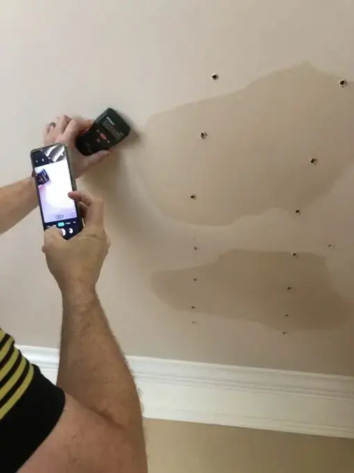 Moisture meter reading a water-stained wall during water damage drying in El Monte