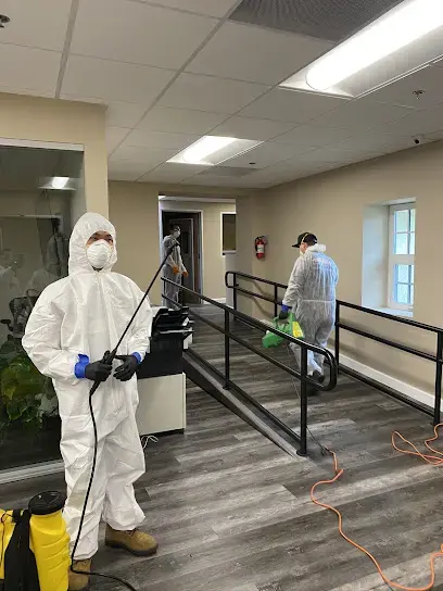 Crew in protective suits applying antimicrobial after a water loss in an El Monte office