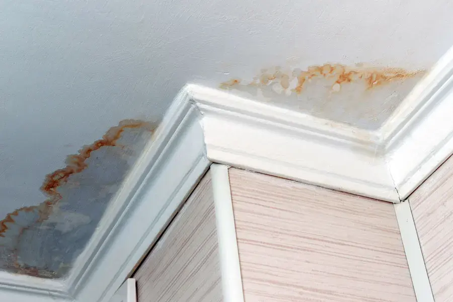 Water stains along a ceiling and crown molding from a unit above in an El Monte condo