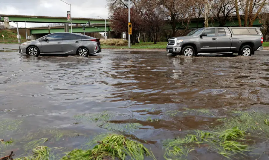 Cars driving through a flooded street during a winter storm near El Monte