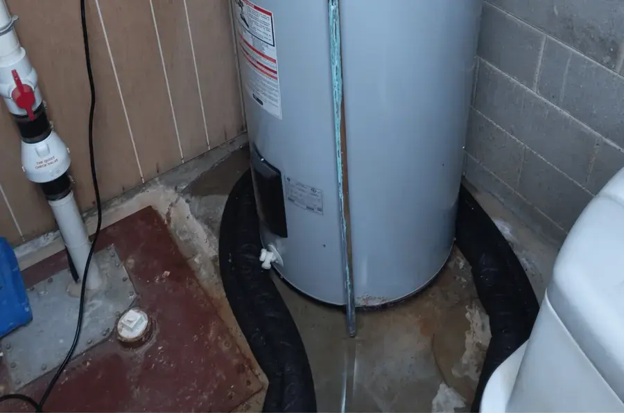 Water pooled around a leaking tank water heater in an El Monte closet